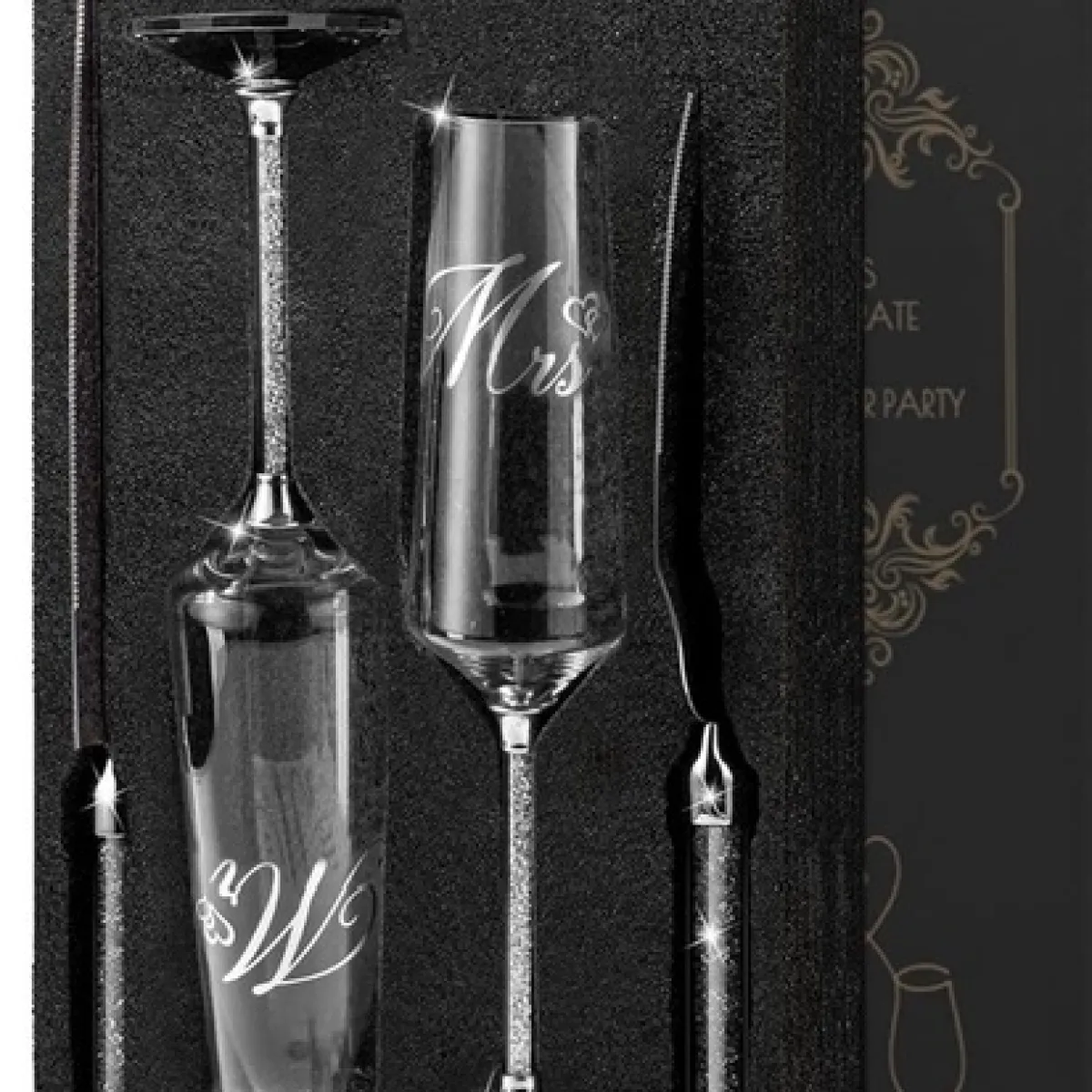 Boxed set with 'Mr' and 'Mrs' champagne flutes and silver utensils.