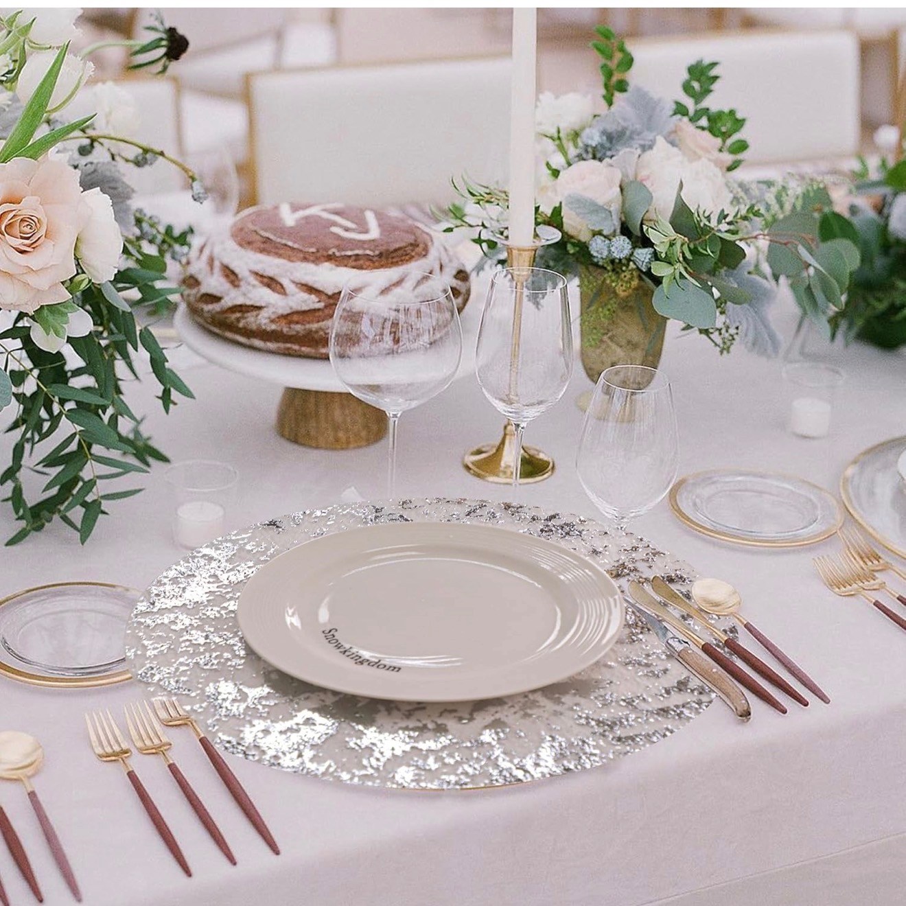 Elegant table setting with flowers, cake, and silver accents.